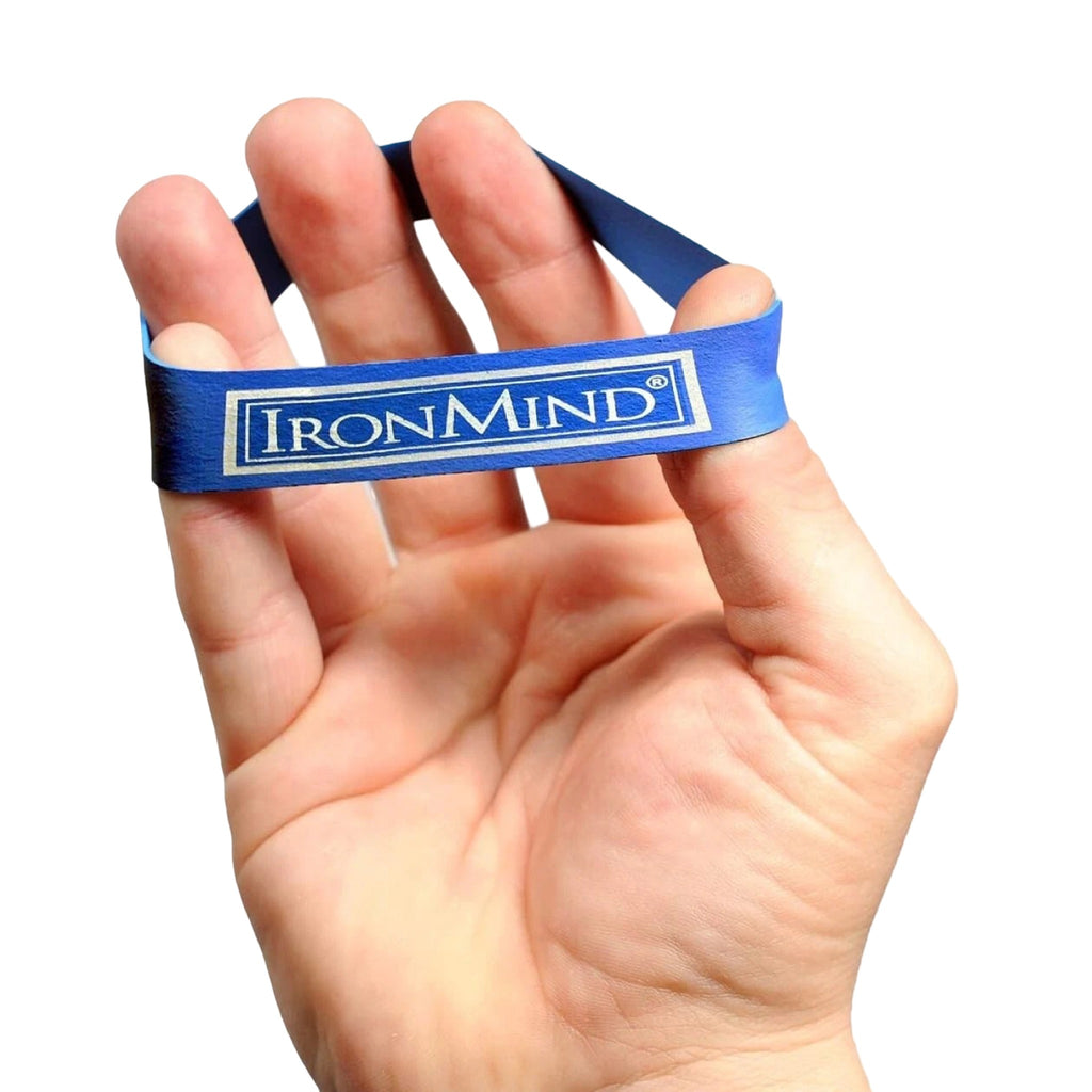 Blue IronMind Expand-Your-Hand Band looped over the fingertips and thumb for finger extensor training