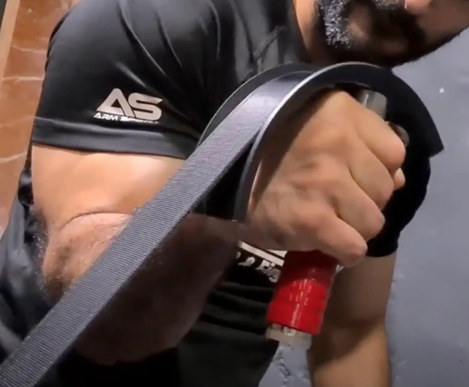 Person using the MultiPuller wrist and forearm trainer during a workout for enhanced grip strength